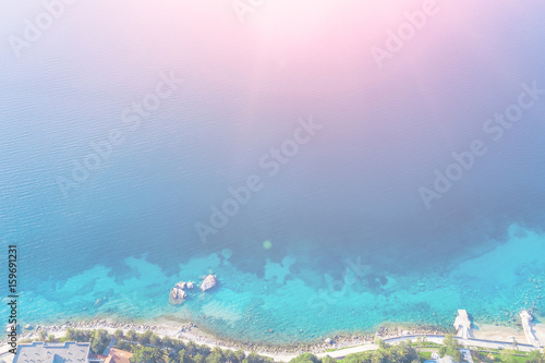 Top view of the sea and the path along the shore in the sunlight