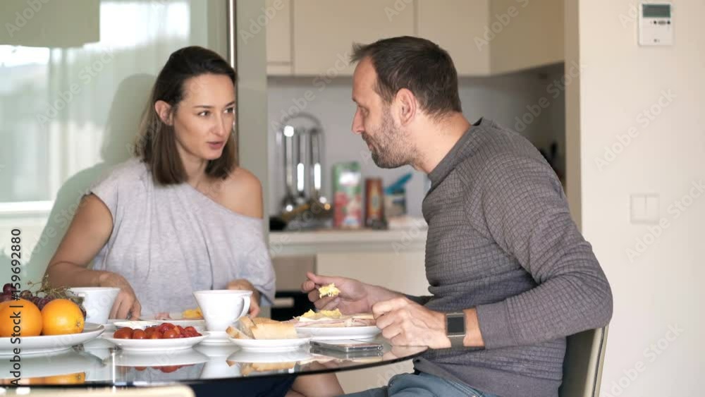 Young couple talking during breakfast at home
Young couple talking during breakfast at home