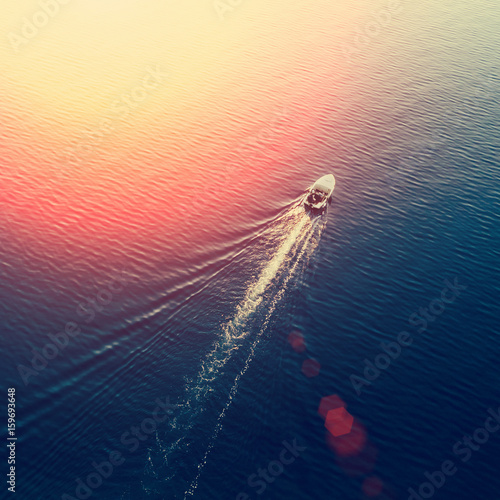 Top view of a white boat sailing in the blue sea on a sunny day © watman