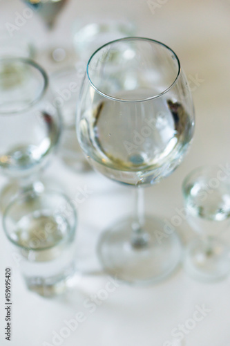 Close-up of glasses of crystal clear drinking water on a white table. Shallow depth of focus. Health concept from nature.