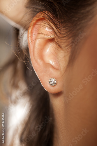 Valokuvatapetti Closeup female ear with a small luxurious earring