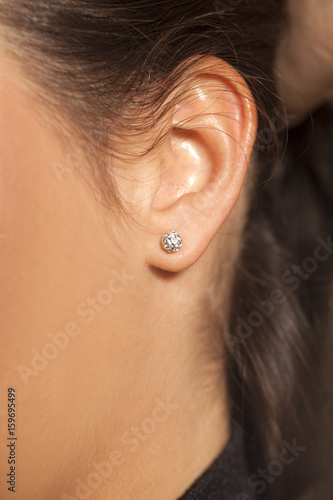 Photo Closeup female ear with a small luxurious earring