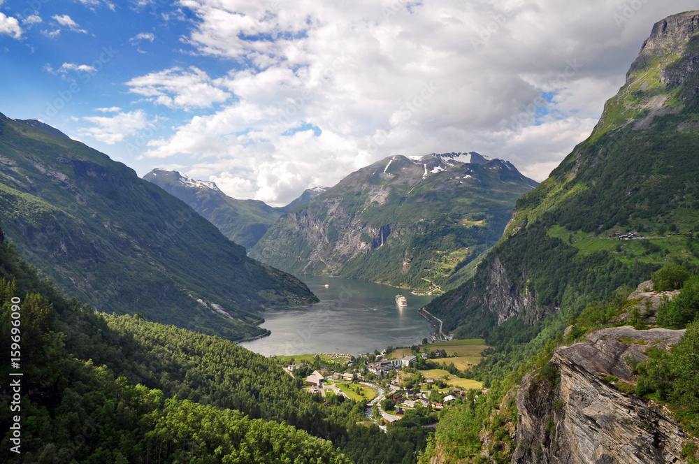 The town of Geiranger in Norway with a fjord, a deep valley and the sea.