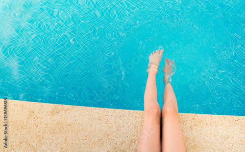 Young woman splashing feet in pool