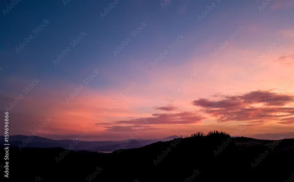 silhouette landscape under sunset sky in spring with clouds in the background, spring time at dusk