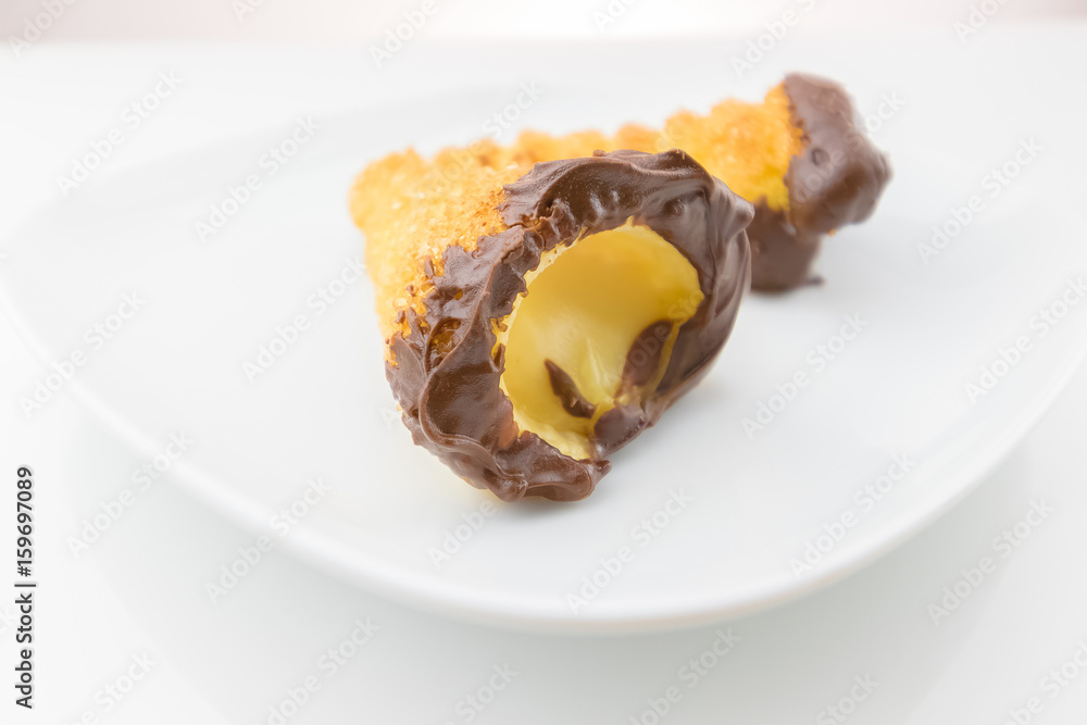delicious sicilian cannolo cannellino sweet with pastry hazelnut chocolate and pastry cream, italian puff-pastry on white background, nutrition and diet