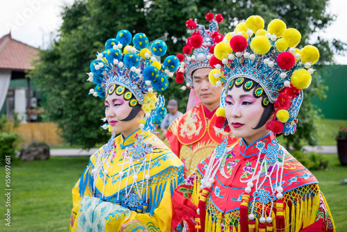 group of three asian people, man and women outdoor in traditional chinese costumes