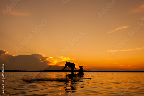 Silhouette,Two fishermen using nets for fishing,sun background  © mteeandt
