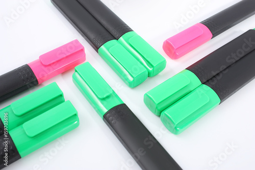 Pink and green markers on a white background