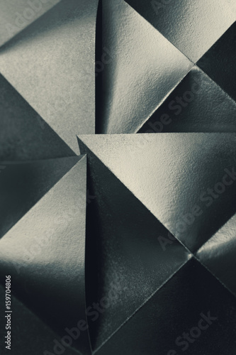  Silvery paper sheets folded in pyramidal shapes, abstract background