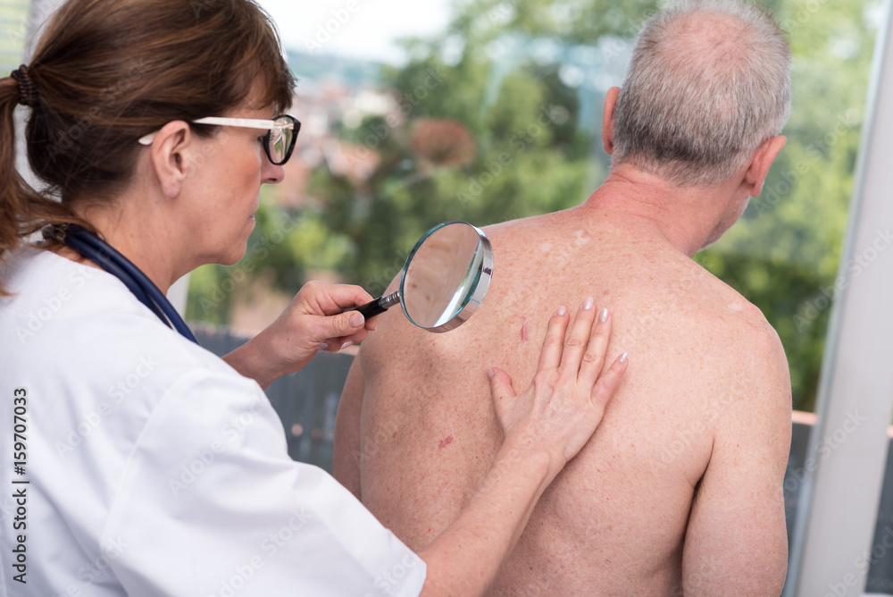 Fotografie Dermatologist examining the skin of a patient