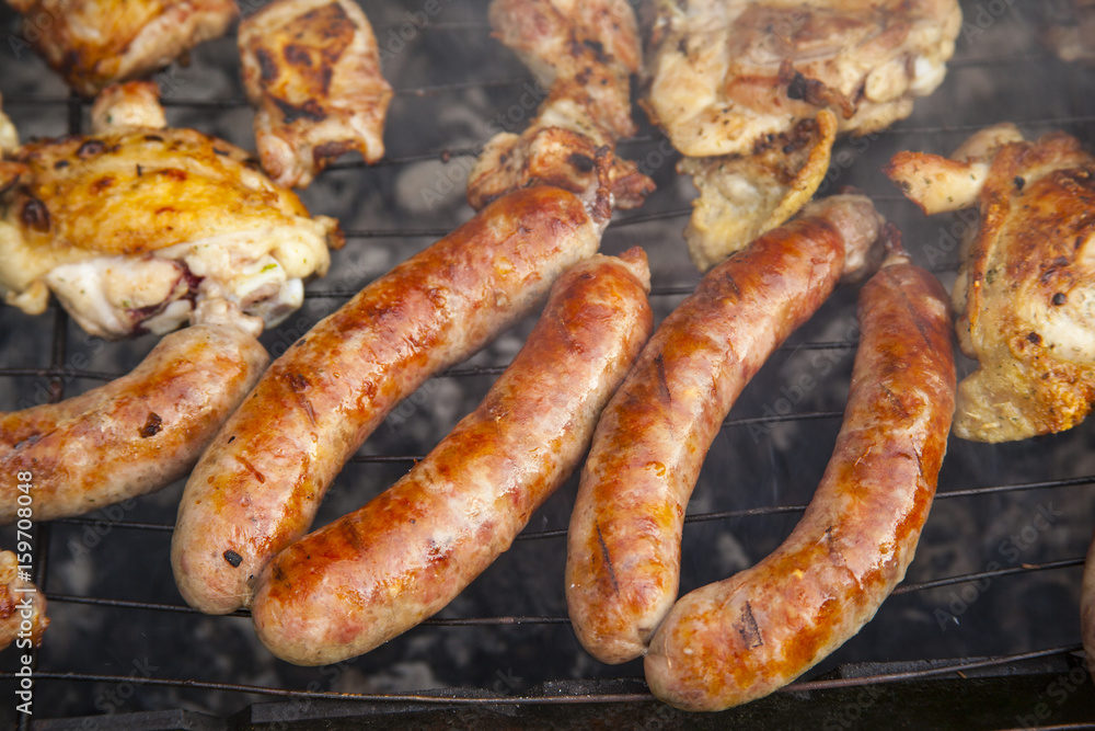Grilled meat. Sausages on a barbecue. Grilling spiced chicken in grid on charcoal bbq. Grilled meat. Sausages on a barbecue. Grilling spiced chicken in grid on charcoal bbq.