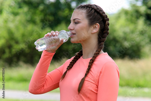 Frau trinkt Wasser während Sport