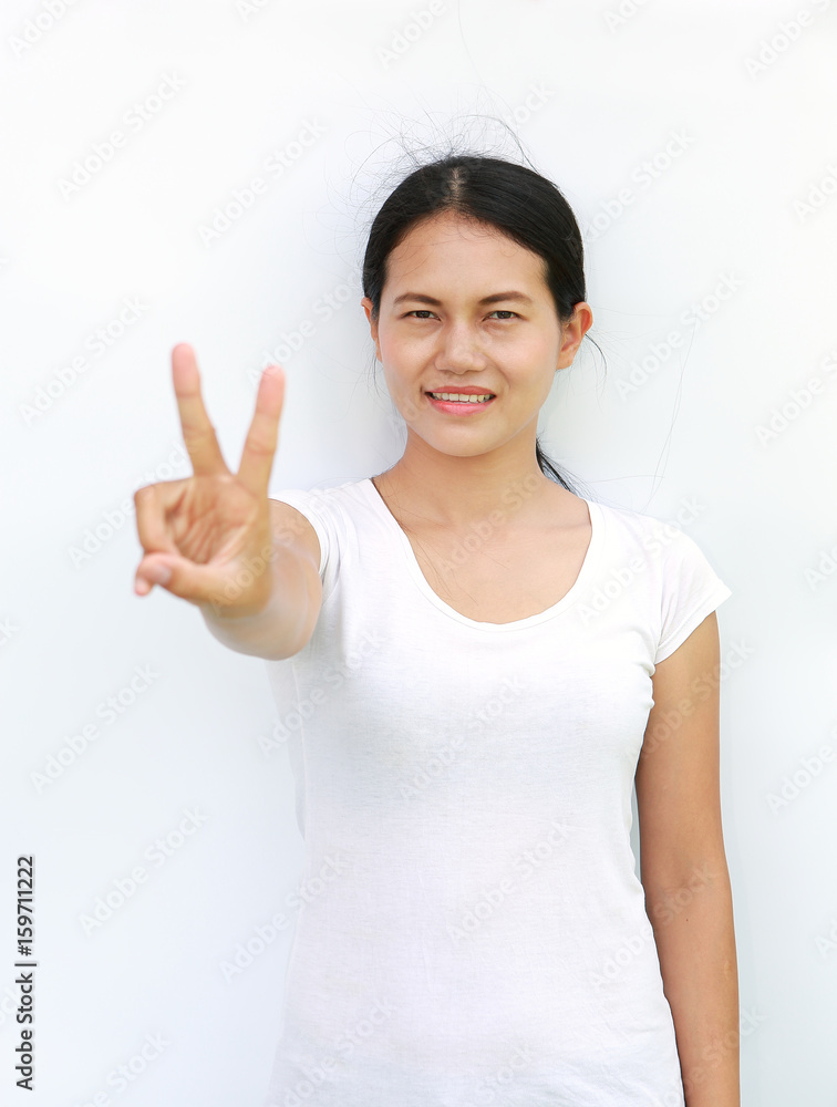 Young asian woman in T-Shirt Showing expression a two-finger victory, Selected focus at her face.