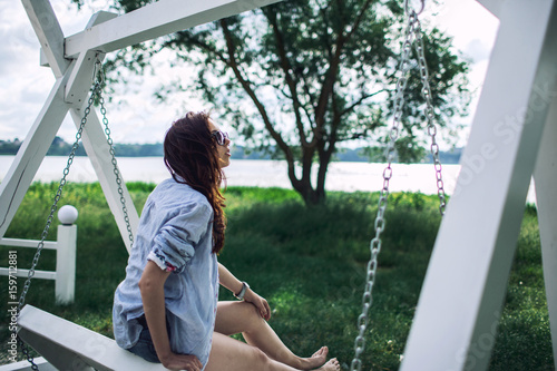 Young beautiful woman sitting on bench in the beach