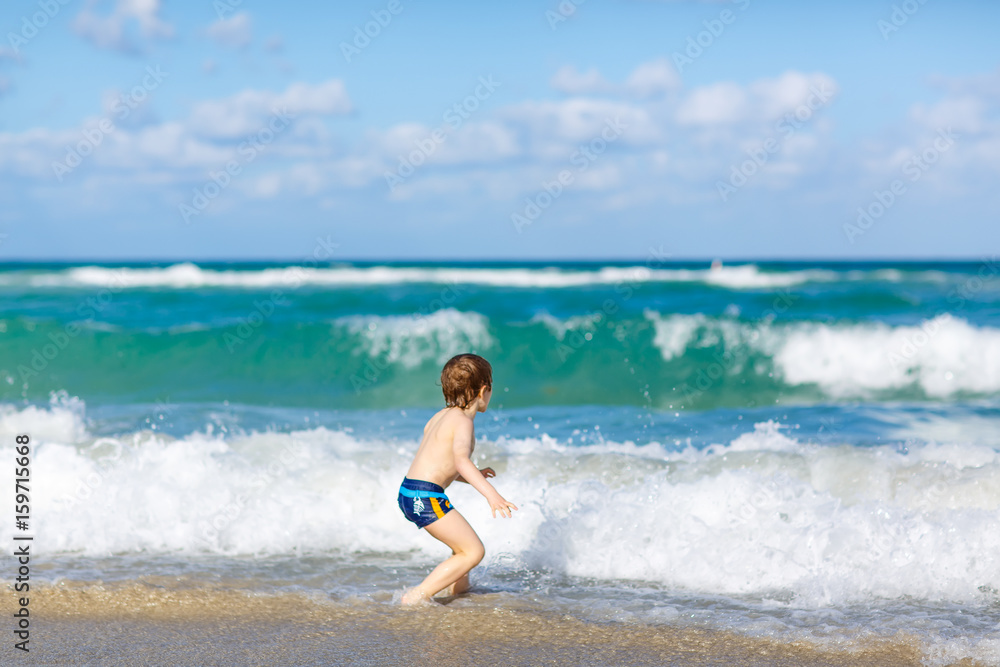 little blond kid boy having fun on ocean beach in Florida little blond kid boy having fun on ocean beach in Florida