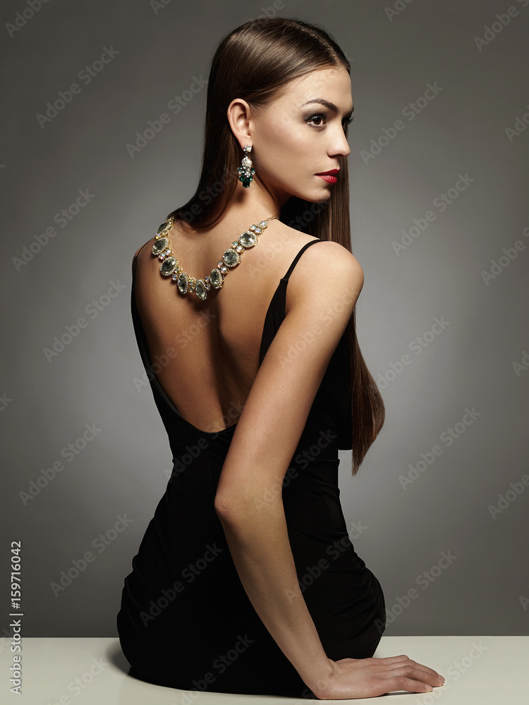 Naklejka premium beautiful young woman in sexy dress and jewelry