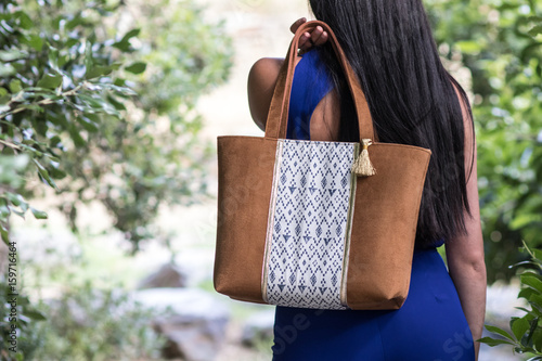 Jeune femme se balade dans la nature avec son sac à main sur l'épaule