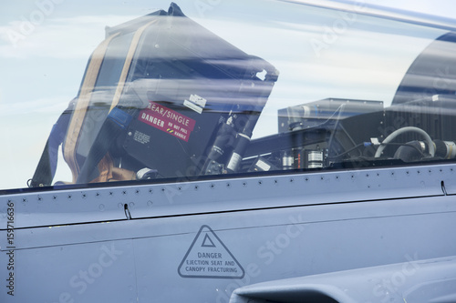 Cockpit of a tactical jet fighter with seat and instructions how to eject from the plane. Danger texts on the metal surface.