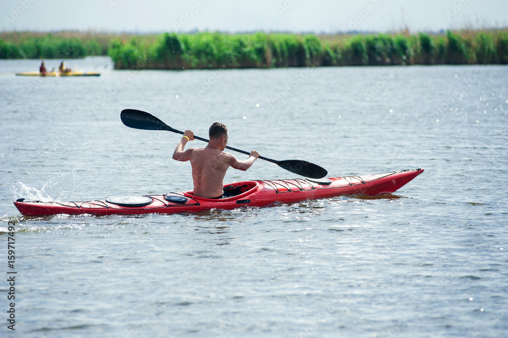 man swims on a red kayak 01
