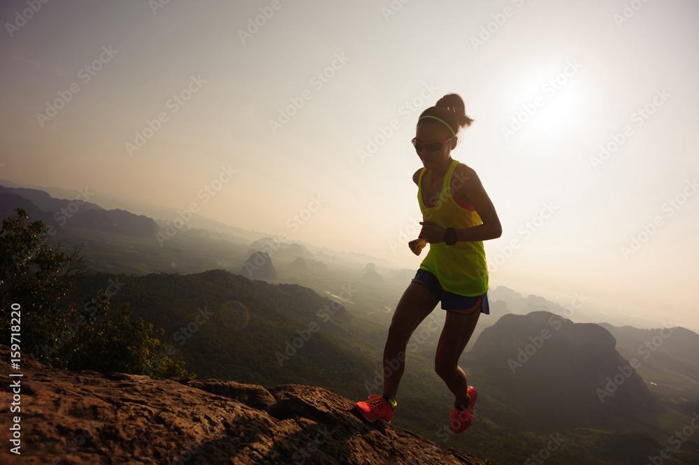 young woman running up on mountain top