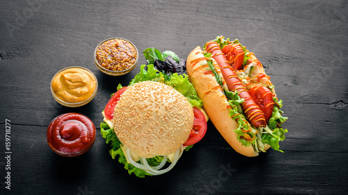 Εκτύπωση καμβά Hot dog and hamburger with cheese, meat and greens on Wooden background
