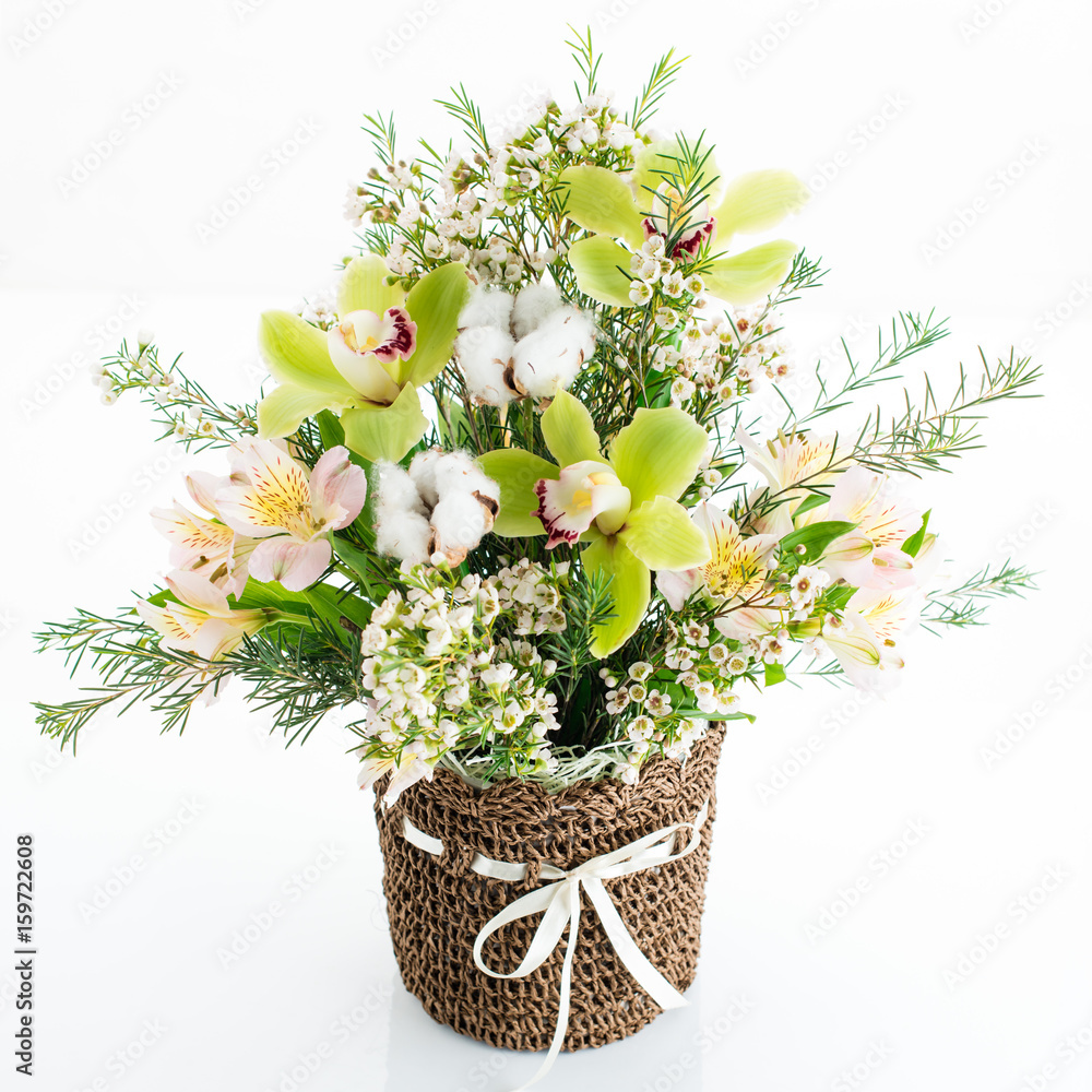 a bouquet of orchid flowers in a wicker basket