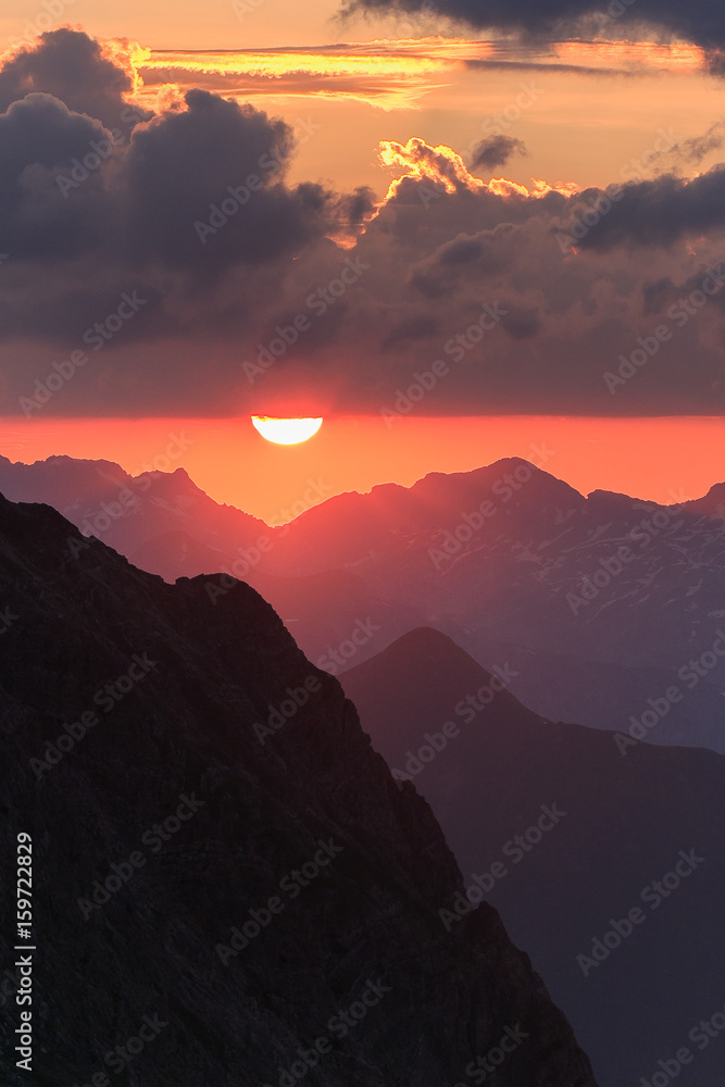 Red sunset on black rocks