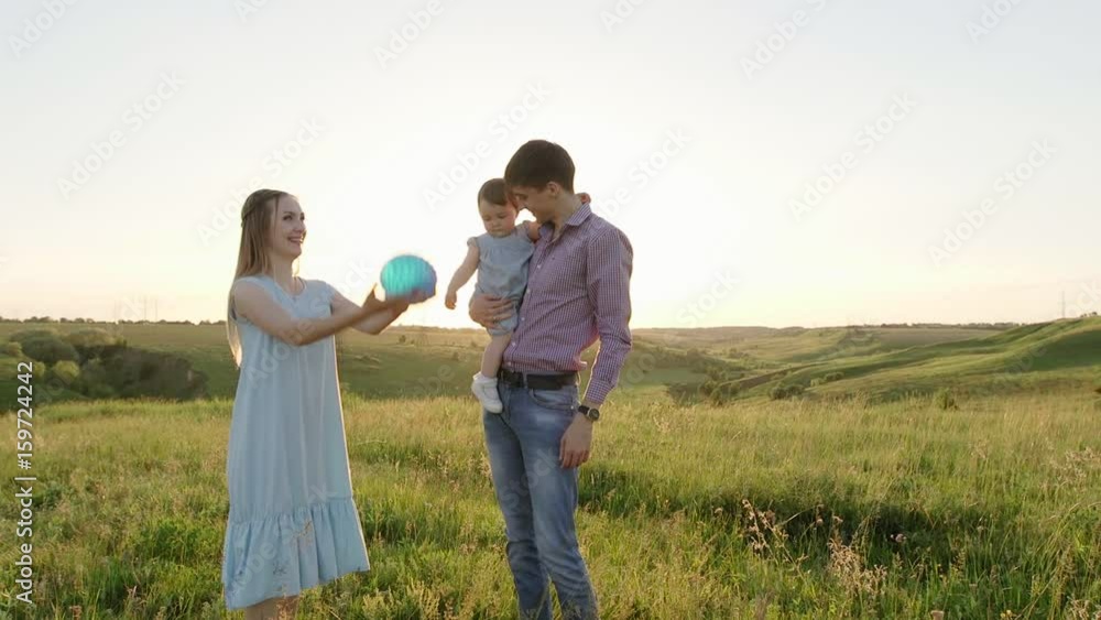 Happy young parents playing and laughing with his young daughter in the summer at sunset. Concept of family Happy young parents playing and laughing with his young daughter in the summer at sunset. Concept of family