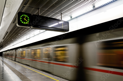 Photography Vienna (Austria) subway underground station with a train running beside the plat