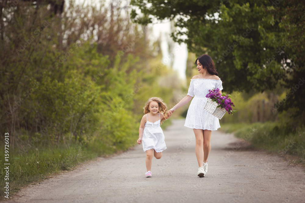 Young beautiful mother and little daughter having fun together. Pretty mom and cute girl outdoors. Cheerful family together rinning taking by the hand Young beautiful mother and little daughter having fun together. Pretty mom and cute girl outdoors. Cheerful family together rinning taking by the hand