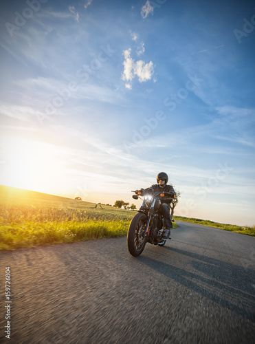 Dark motorbiker riding high power motorbike in sunset © Jag_cz