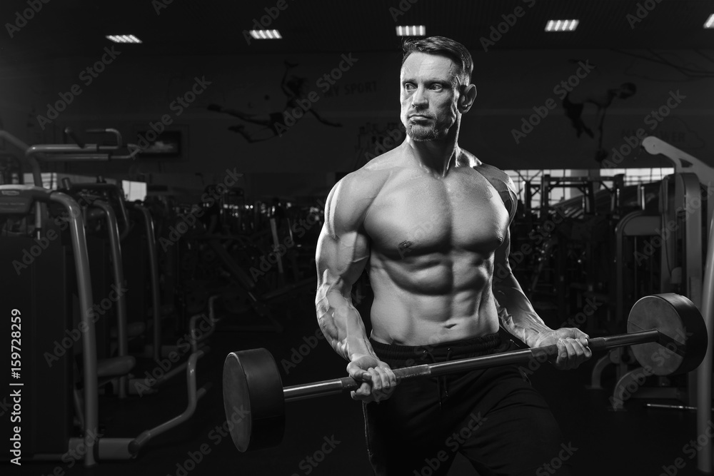 Middle aged fitness model lifting barbell in gym Middle aged fitness model lifting barbell in gym