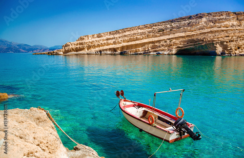 Matala beach, old fishing boat and caves on the rocks that were used as a roman cemetery and at the decade of 70's were living hippies from all over the world, Crete, Greece. Rock festival.
