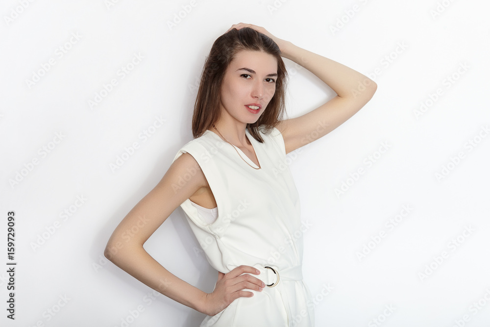 Young beautiful brunette beginner model woman in white blouse practicing posing showing emotions on white wall studio background Young beautiful brunette beginner model woman in white blouse practicing posing showing emotions on white wall studio background