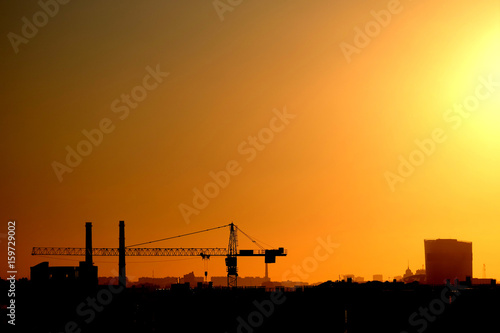 Photo of a building process in the city in the sunset.