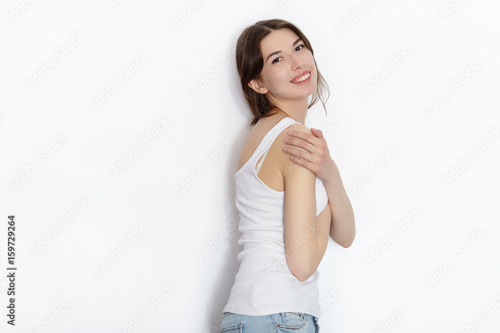 Young beautiful brunette beginner model woman in white t-shirt blue jeans practicing posing showing emotions on white wall studio background Young beautiful brunette beginner model woman in white t-shirt blue jeans practicing posing showing emotions on white wall studio background