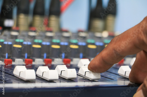 hand on a sound mixer control equipment old which has dust. select focus with shallow depth of field.
