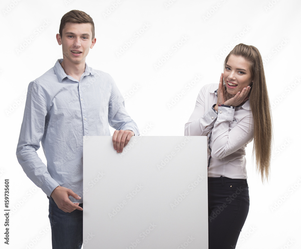 Young happy couple showing presentation pointing on placard over Young happy couple showing presentation pointing on placard over