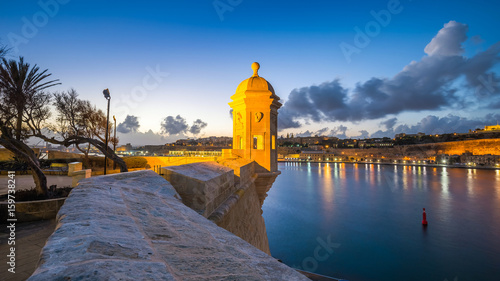 Senglea, Malta - Watch tower at Fort Saint Michael, Gardjola Gardens and the walls of Valletta at blue hour with beautiful sky and clouds