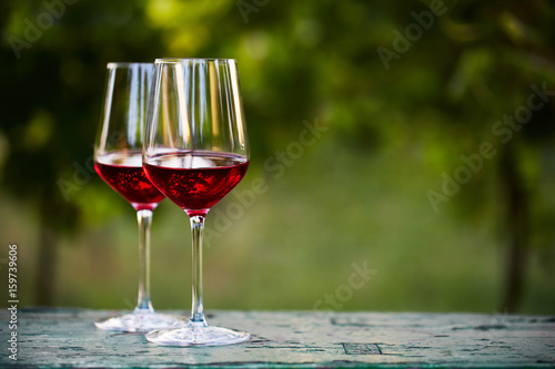 Two glasses of red wine on table in the vineyard