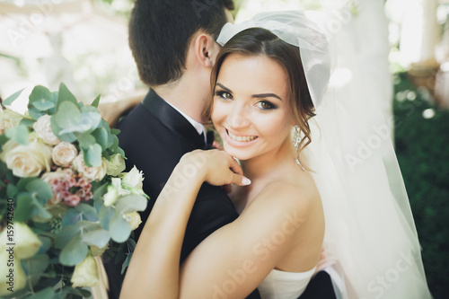 Stylish beautiful couple of happy newlyweds on their wedding day, close up portrait