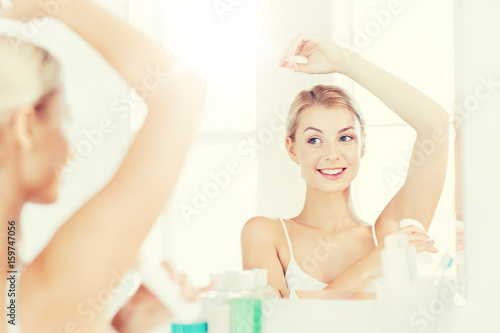 woman with antiperspirant deodorant at bathroom