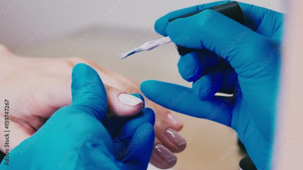 Master in gloves makes a manicure close-up Master in gloves makes a manicure close-up