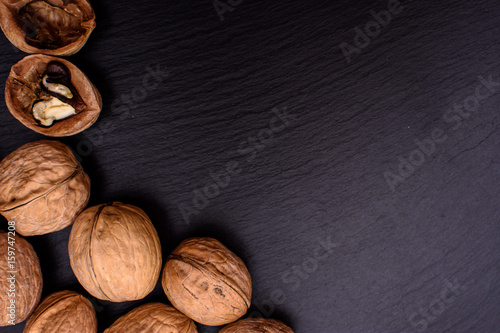 Walnut on black stone board background, frame space for text