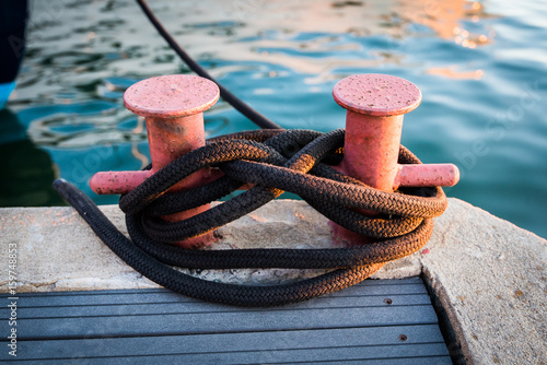 Fotografia Mooring Bollard with rope on pier by the sea.