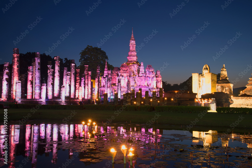 Obraz premium Ruins of the ancient Buddhist temple Wat Mahathat in purple lighting in the late evening. Historical Park of Sukhothai, Thailand