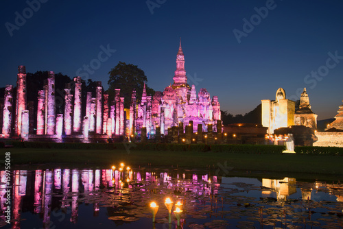 Ruins of the ancient Buddhist temple Wat Mahathat in purple lighting in the late evening. Historical Park of Sukhothai, Thailand