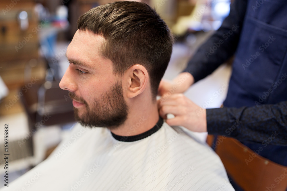 Fototapeta premium hairdresser and man with beard at barbershop