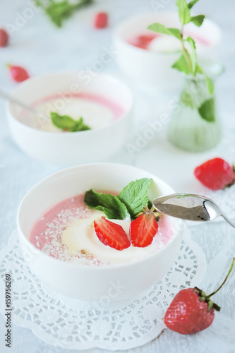Cold creamy strawberry soup with a scoop of ice cream and mint